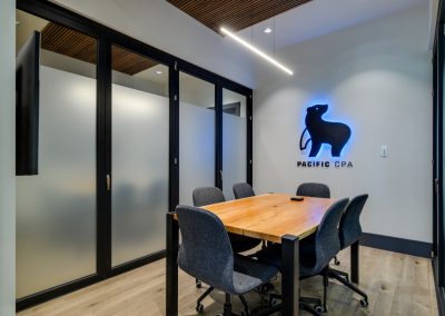 Boardroom table with the lit Pacific CPA bear logo