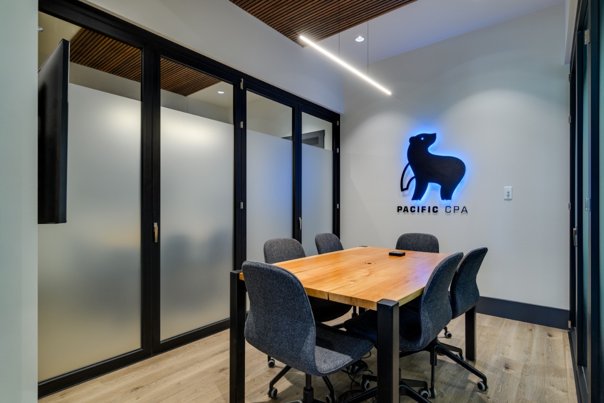 Boardroom table with the lit Pacific CPA bear logo