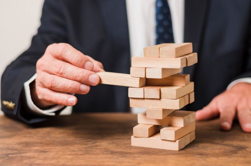 Hand moving a block in a stacked block tower