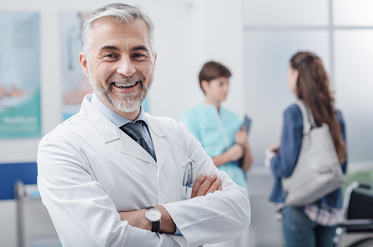 Doctor in a clinic with staff behind